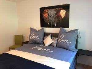 泰特南Apartment Green Elephant的一张带蓝色枕头的床和一张大象的照片