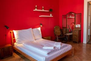 布拉格克洛维巴德旅馆的卧室设有红色墙壁,配有一张床