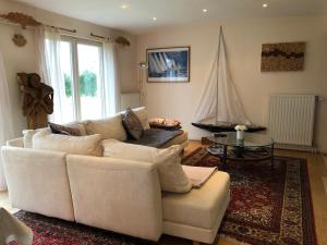 欧本Landhaus Sylvia的客厅配有白色沙发和帆板