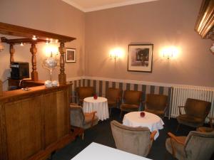 希斯特尔坦普特酒店的一间设有两张桌子和椅子的等候室