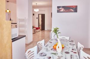 康斯坦察Gabizz Apartments的一间用餐室,配有一张桌子和花瓶