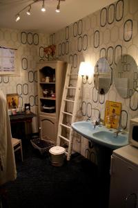 FontainesMaison d'hôtes LE LAVOIR的浴室设有水槽和带镜子的架子