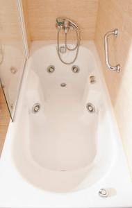布尔戈斯布尔戈斯卡米诺圣地亚哥修道院酒店的带淋浴的浴室配有白色浴缸。