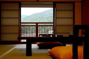 箱根Hakone Onsen Ryokan Yaeikan的客房设有一张床和一个美景窗户。