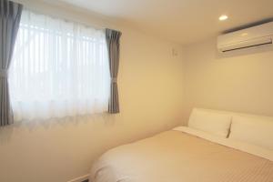 富士吉田市Villas Waraku的一间卧室设有一张床和一个窗口