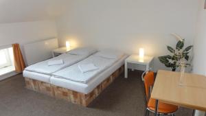 兹诺伊莫U哈拉德伯膳食公寓的一间卧室配有一张床和一张带两个蜡烛的桌子。