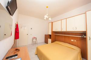 瑟克罗Hotel Da Italo的一间卧室配有一张床、一张书桌和一台电视。