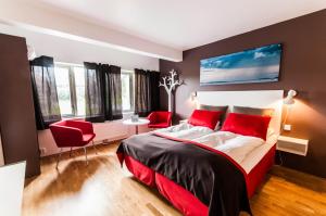 MelandsjøenDolmsundet Hotell Hitra的一间卧室配有一张带红色枕头的大床