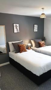 奥尔德伯里Anvil Drive - Birmingham BnBs的一间带两张床和一张沙发的卧室