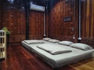 安帕瓦班桑湾民宿 的木墙客房的两张床