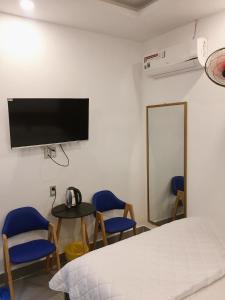 昆岛THAO LIEN HOTEL的一间卧室配有一张床铺和椅子以及一台电视。