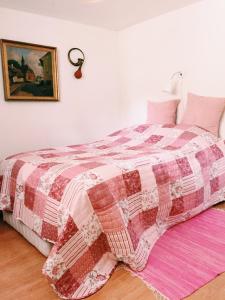 埃贝尔托夫特Ebeltoft Midtby的一间卧室配有一张带红白色棉被的床