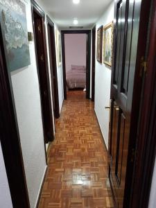塞维利亚Apartamento zona Palacio de las Dueñas y las Setas的走廊上设有一张床和木地板的房间