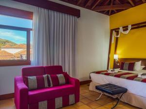 桑蒂亚戈德尔泰德卡索那德尔庭院旅馆的卧室配有床、椅子和窗户。