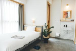 大阪Hotel Noum OSAKA的一间卧室配有一张床和盆栽植物