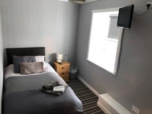 BeithSaracen Head Hotel的一间卧室设有一张带电视和窗户的床。