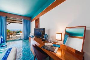 马萨鲁布朗斯罗司考格里奥酒店的一间卧室配有书桌和一张带镜子的床