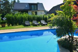 卡劳特格瑞斯赫Ferienwohnung Gohrisch的一座房子旁的游泳池,配有两把躺椅