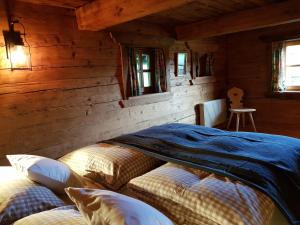 WeisspriachFerienbauernhaus Stergut的小木屋内一间卧室,配有两张床