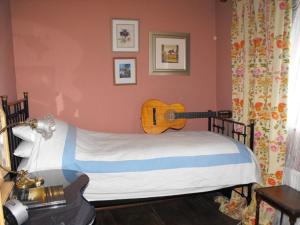兰卡斯特Whitmore的卧室配有一张壁挂吉他的床
