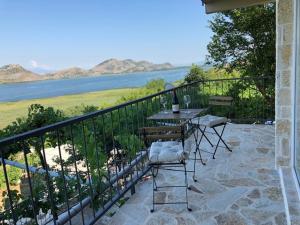 波德戈里察Skadar lake house Bobija的阳台配有桌椅,享有水景。