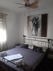 普洛切Apartman Astra的一间卧室配有一张带键盘的床和风扇
