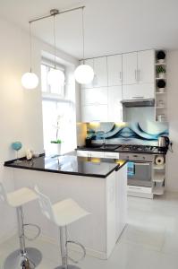 格涅兹诺Apartament Domi的厨房配有白色橱柜和黑色台面