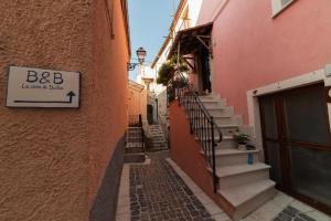 FornelliLa casa di Duilia的楼边有楼梯和标志的小巷