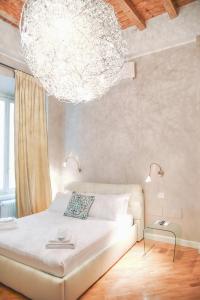 贝加莫Ilsanleonardo的一间卧室配有一张带大吊灯的床