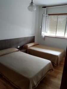 里瓦德奥HOSTAL RESIDENCIA PRESIDENTE的小型客房 - 带2张床和窗户