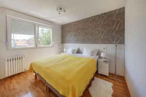 奥西耶克Apartman Osijek的一间卧室配有一张带黄色床罩的大床