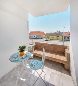 奥西耶克Apartman Osijek的客房设有桌椅和阳台。