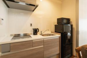 别府GRAND BASE Beppu的一间带水槽和冰箱的小厨房