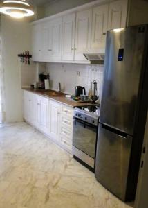 哈尔基斯Sea View Apartment的厨房配有白色橱柜和不锈钢冰箱