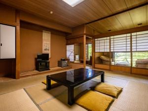 箱根箱根温泉山庄酒店的客厅配有桌子和电视