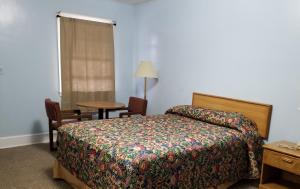 兰伯顿经济汽车旅馆的卧室配有1张床、1张桌子和1把椅子