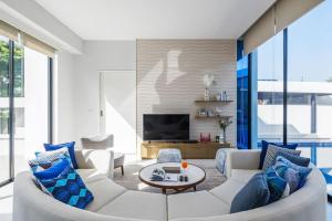 纳仲天Mövenpick Luxury Villa2FL-Private Pool-SHA CERTIFIED的客厅配有白色沙发和蓝色枕头。