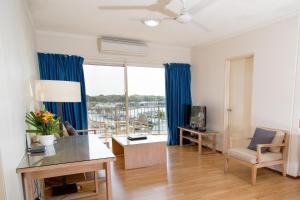 达尔文Cullen Bay Resorts的客厅配有蓝色窗帘和大窗户