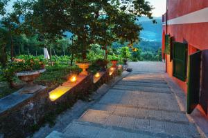 斯培西亚塞罗荣格农场酒店的花园旁的一条带灯的走道