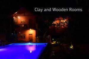 丹不拉Sun and Green Eco Lodge - Dambulla的游泳池在晚上点亮,紫色灯