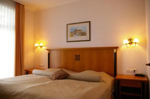 宾茨Meerblick-Appartement Villa Gudrun的卧室配有一张带两盏灯的墙壁床。