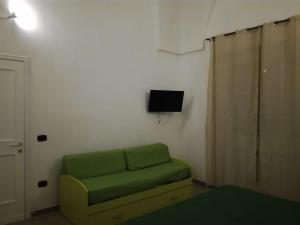 莱韦拉诺La casa di Mela的客厅配有绿色沙发和电视