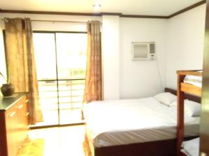 Cabugao NorteJem Jeff Residence Inn的一间卧室设有一张床和一个大窗户