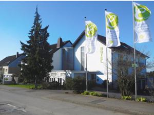 奥登塔尔埃堪佩霍赫酒店的前面有两面旗帜的建筑