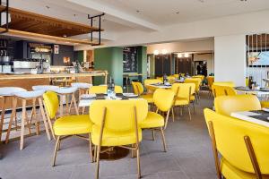 开普敦First Group Riviera Suites的用餐室设有黄色的椅子和桌子