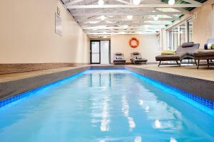 开普敦First Group Riviera Suites的大楼内的一个蓝色海水游泳池