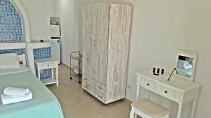 胡拉吉亚Antoninis Village的一间卧室配有床、梳妆台和橱柜。