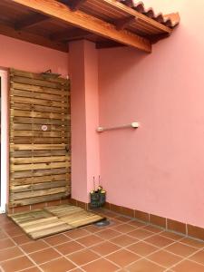 大塔拉哈尔Ático Sun&Beach的一间设有木墙的客房,毗邻粉红色的墙壁