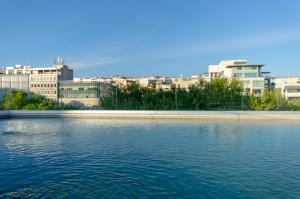 里斯本TURIM Boulevard Hotel的一大片水体,有建筑背景