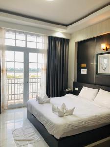 万象Sunset Mekong Apartment的卧室设有一张大白色的床和大窗户